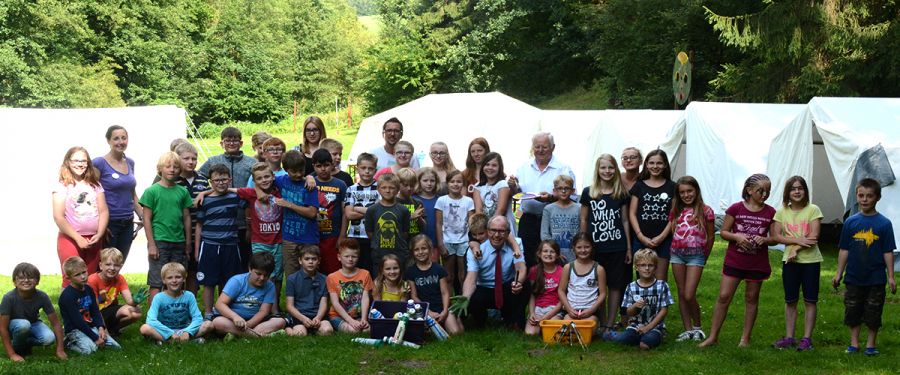Haben mit dem Paderborner Kreisjugendamt Spaß auf dem Zeltplatz in Siddinghausen: Landrat Manfred Müller (1. Reihe mittig im Bild) und Friedhelm Kaup (hintere Reihe, neunter von rechts) besuchten die 43 Kinder aus dem Kreis Paderborn . (Foto:  Amt für Presse- und Öffentlichkeitsarbeit, Kreis Paderborn, Anna-Sophie Schindler)